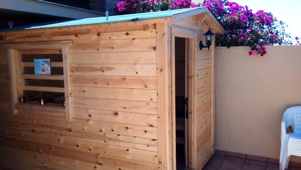 Caseta de madera de pino en una terraza con buganvilla